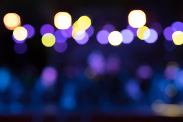 Beautiful blurred background of the nighttime stage show with yellow, purple and blue lights