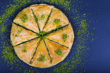 circle Baklava slices Turkish ramadan Dessert with blue background