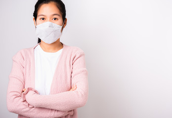 Asian beautiful woman wearing protection face mask against coronavirus standing crossed arm, studio shot isolated on white background with copy space, COVID-19 or corona virus concept