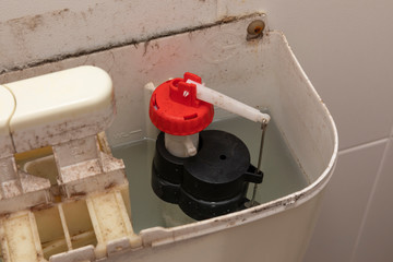 The internal mechanism on an old and dirty toilet cistern