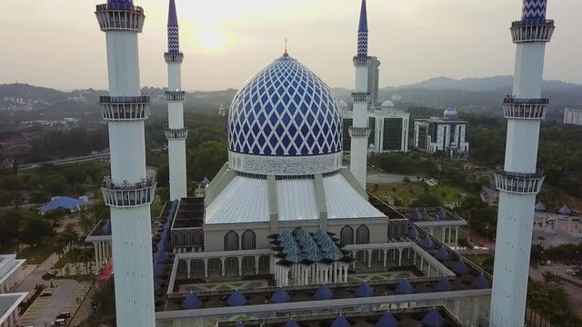 Orbiting Sunset Aerial Footage of Sultan Salahuddin Abdul Aziz Mosque Shah Alam. The white and blue mosque of Shah alam