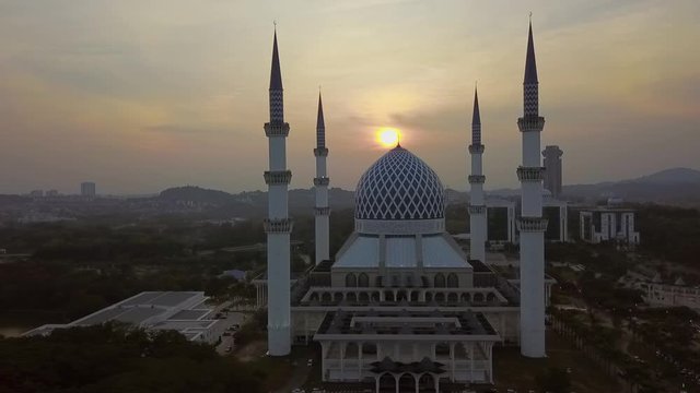 Orbiting Sunset Aerial Footage of Sultan Salahuddin Abdul Aziz Mosque Shah Alam. The white and blue mosque of Shah alam