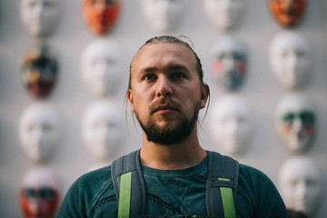 Obraz premium Portrait of a man in the background of a wall with faces