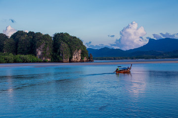 The background of a small fishing boat that is about to dock and there is a blur of water flowing through, being a coexistence of people and nature.