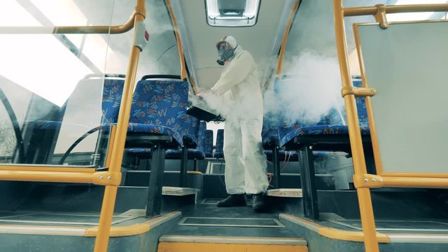 Interior of a bus is getting disinfected with a fumigator