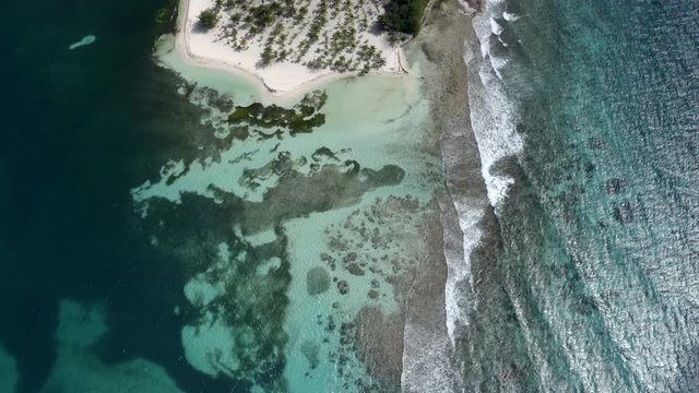 Aerial view of waves splashing shore at island, drone flying over beach - Coco Plum Cay, Belize