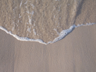 Top view of clear seawater on the brown sand beach 