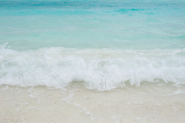White foam of sea wave on the beach
