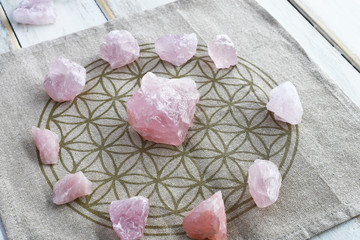 A close up image of a several rose quartz crystal in a energy healing grid using sacred geometry. 