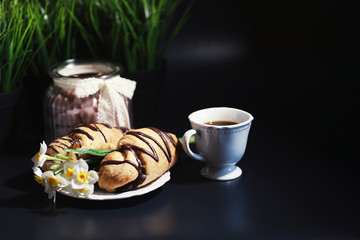 French breakfast on the table. Coffee croissant with chocolate and a decanter with cream. Fresh...