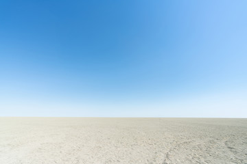 Fototapeta na wymiar Landscape view of salt pan with clear blue sky. Empty vast view of white sand desert in Etosha nation park.