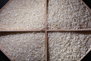 A set of grain cereals. Rice, buckwheat and millet groats in a wooden tray. A grocery set of cereals. Import of grain.