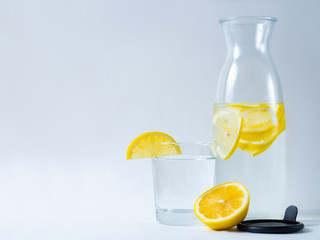 carafe with lemonade from lemons with a glass on a light background