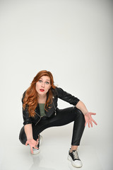 Young woman shows emotions changing poses while sitting on the floor. Portrait of a pretty girl...