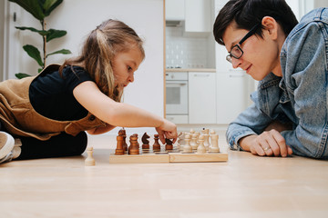 Little girl is enthusiastic about her move, playing chess against her father