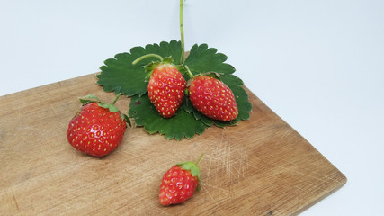 Fresh strawberries on a wooden table isolated on white background