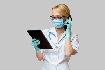medical doctor nurse woman wearing protective mask and gloves - holding tablet pc and mobile phone