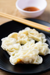 Steamed wonton dumpling stuffed with minced pork and shrimp eating with sesame oil sauce, Asian food