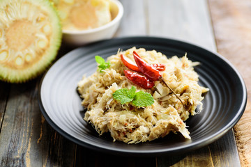 Northern Thai food (Tam Khanun), spicy pounded young jackfruit salad on wooden background