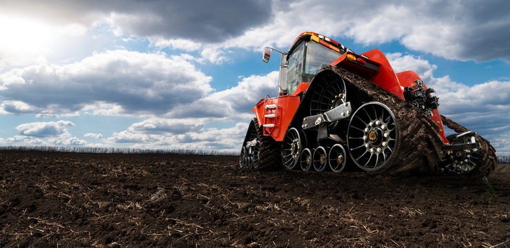 Fototapeta Rubber tracked agricultural tractor on a field.