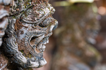Traditional stone statue in Balinese landscape in soft focus