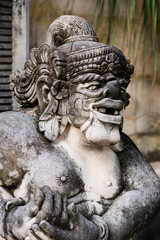 Fototapeta na wymiar Traditional stone statue in Balinese landscape in soft focus