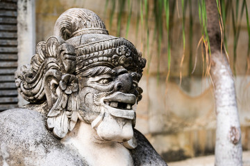 Traditional stone statue in Balinese landscape in soft focus