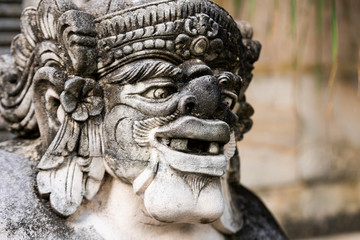 Traditional stone statue in Balinese landscape in soft focus