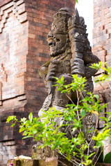 Fototapeta na wymiar Traditional stone statue in Balinese landscape in soft focus