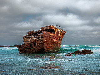 Fototapeta na wymiar South Africa Ship wreck with cloudy sky and turquoise water background