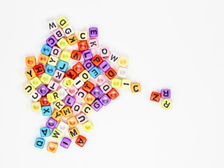 Colorful alphabets beads on white background, selective focus.  concept image