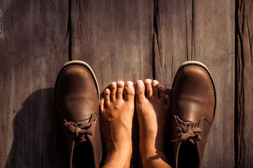 Brown stylish boots on wood background,  retro color