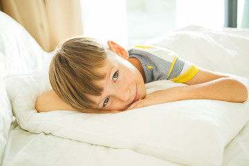 Obraz na płótnie Canvas Cute little boy on a bed.