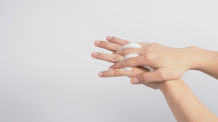 Male model is rub backs of both hands with foaming hand soap on white background.