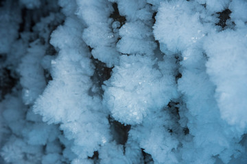 Blue crystal ice grotto cave with icicles, broken ice and snow. Winter landscape. 