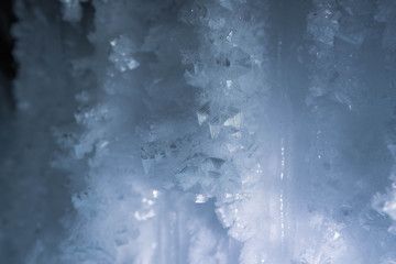 Blue crystal ice grotto cave with icicles, broken ice and snow. Winter landscape. 