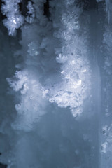 Blue crystal ice grotto cave with icicles, broken ice and snow. Winter landscape. 