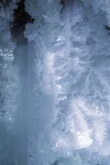 Blue crystal ice grotto cave with icicles, broken ice and snow. Winter landscape. 