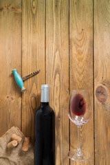 Red wine bottle and red wine glass and old corkscrew