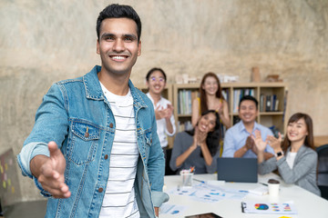 Young indian businessman and team smile, look and give handshake to camera at office in concept warm welcome and support for new comer, deal merger and acquisition business, career and job workforce.