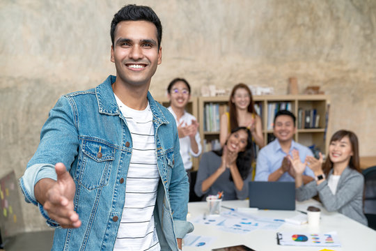 Young Indian Businessman And Team Smile, Look And Give Handshake To Camera At Office In Concept Warm Welcome And Support For New Comer, Deal Merger And Acquisition Business, Career And Job Workforce.