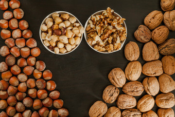Hazelnuts and walnuts in triangle and two fruits bowls in the middle