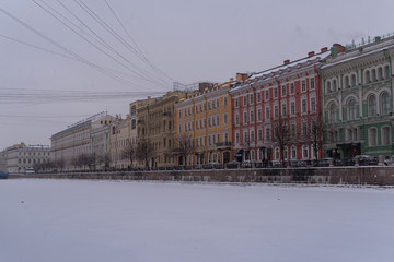 Fototapeta na wymiar Embankment of ice covered Moyka river in snow weather. Saint Petersburg. Russia