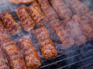 minced meat rolls or mici cooking on barbecue traditional romanain balkan ottoman dish 1st of may...