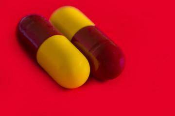 Antibiotic capsules on a red background