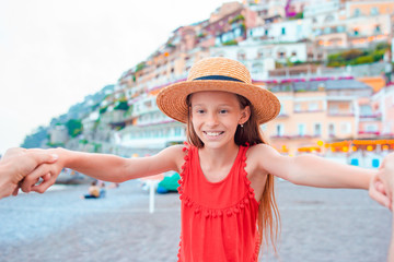 Adorable little girl on warm and sunny summer day in Positano town in Italy