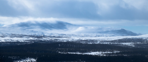 Winter landscape with foggy snowy mountains. Panorama