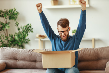 Excited guy with delivery box on couch.
