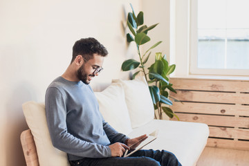 Young handsome man using digital tablet at home, Handsome student studying in his room, Home work...