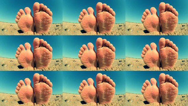 Feet legs strewn sprinkled sand sanded on sandy beach ckose-up.